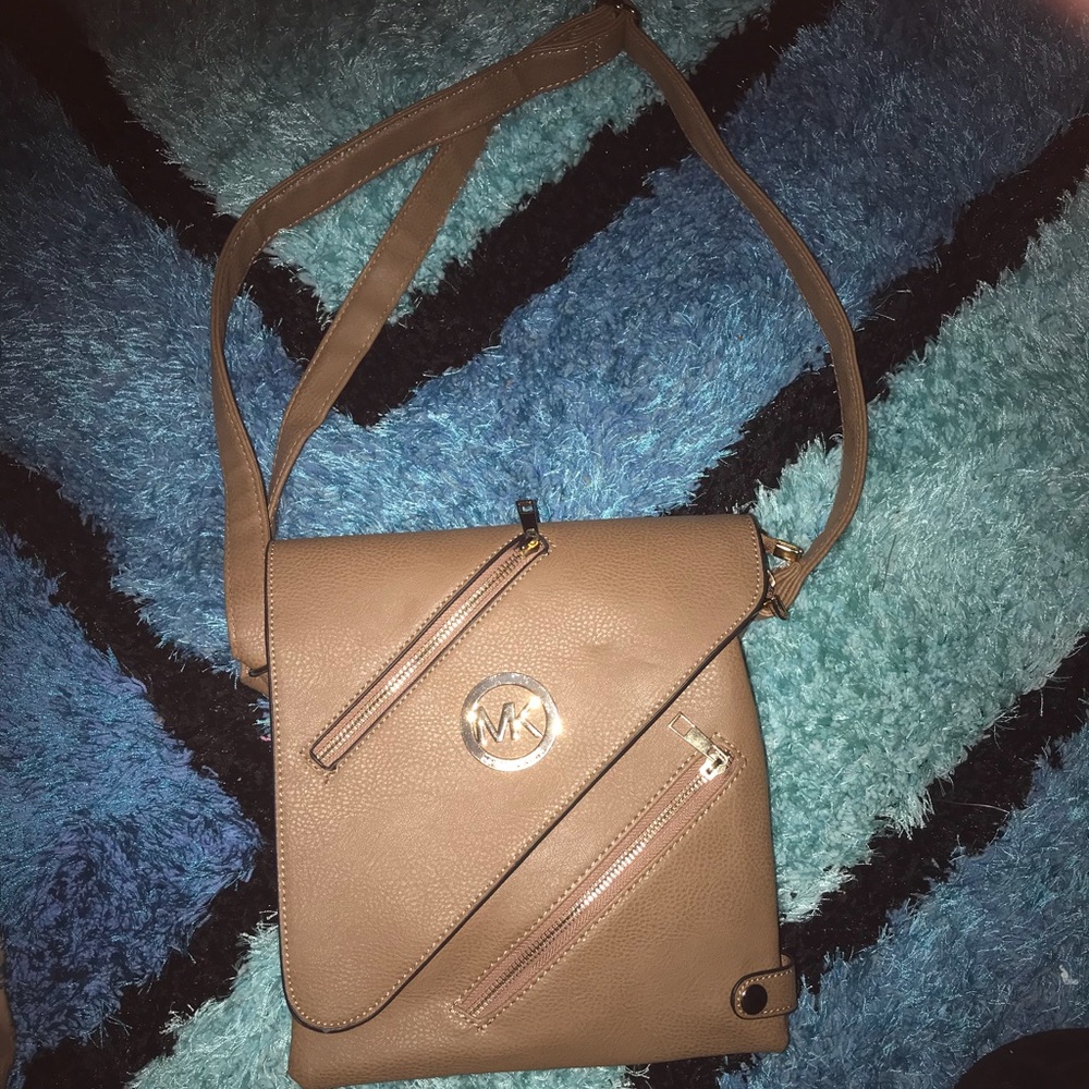Woman’s tan and gold shoulder bag